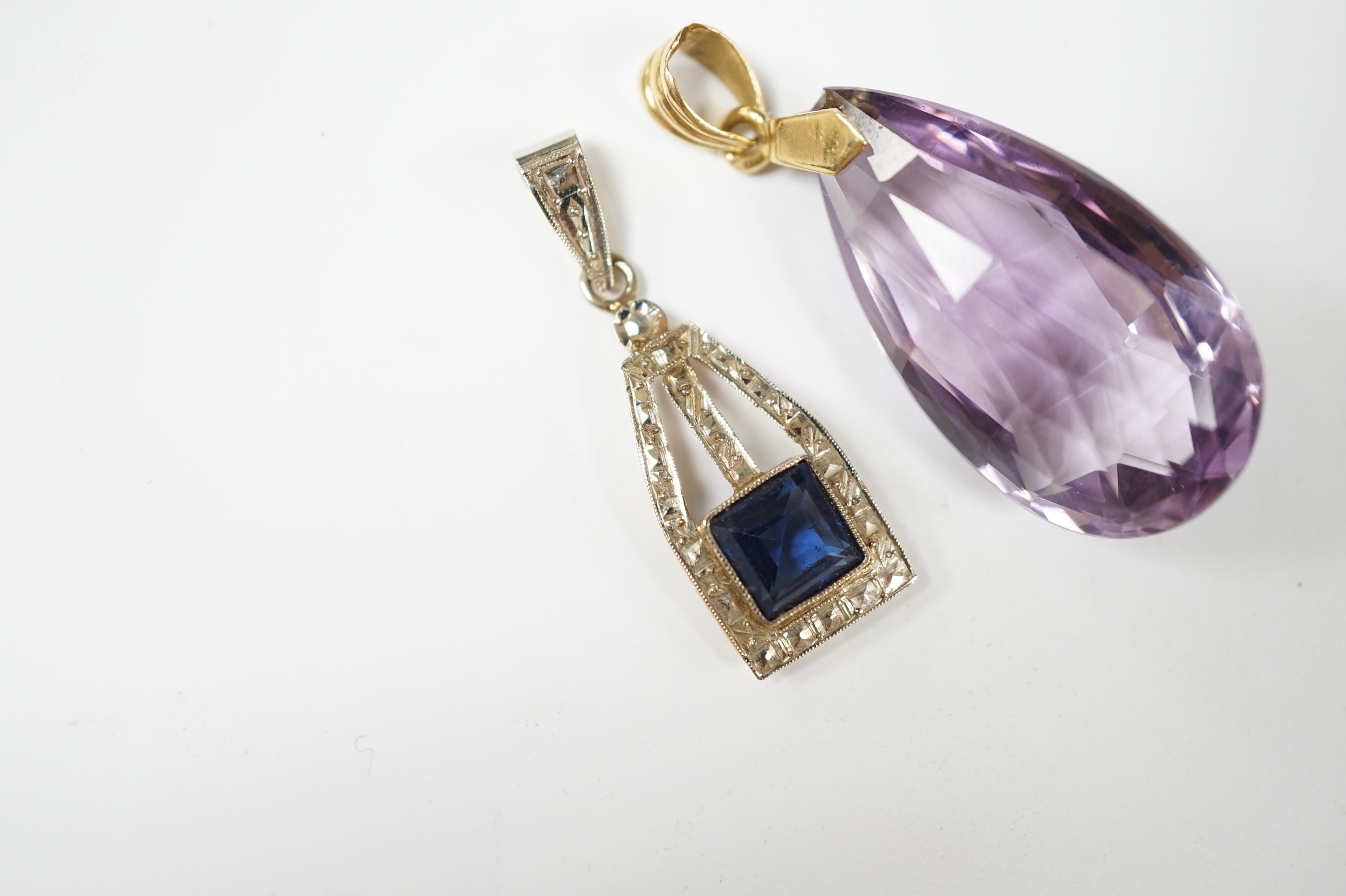 A yellow metal and fancy cut amethyst set drop pendant, 38mm, together with one other blue paste set pendant. Condition - fair